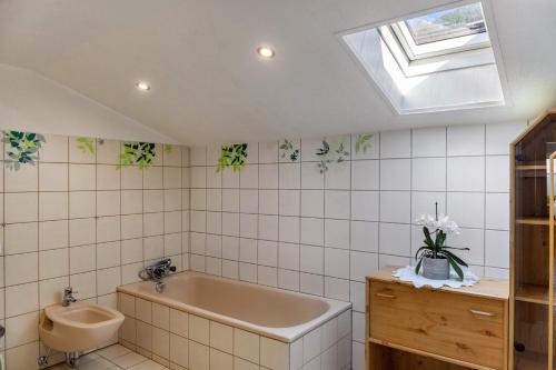 a bathroom with a bath tub and a sink at Ferienwohnung Sylvia in Ramsau im Zillertal