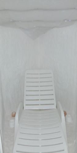 a white bench sitting in a white room at Mornov raj in Vuzenica