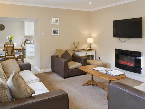 a living room with a couch and a tv and a table at Fordson in Warenford