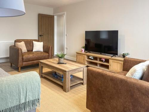 a living room with two couches and a flat screen tv at Barncroft Retreat - Uk51693 in Flimby