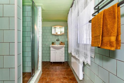 a bathroom with green tiles and a sink at Jaroslav Ambrož Elvomont Chlum u Třeboně in Chlum u Třeboně