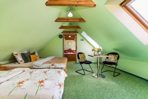 a bedroom with two beds and a table and chairs at Jaroslav Ambrož Elvomont Chlum u Třeboně in Chlum u Třeboně