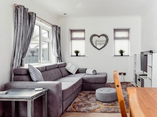 a living room with a couch and a tv at Chalet 4 in Flookburgh