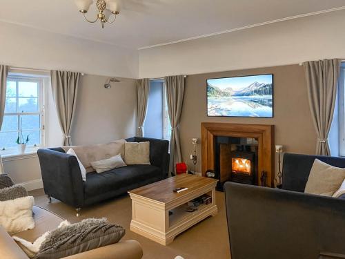 a living room with a couch and a tv at 2 The Langhouse in Inverkip