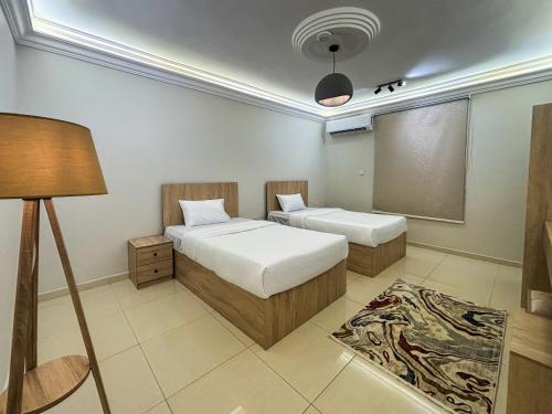 a small bedroom with two beds and a lamp at Nasaem Al Naseem in Medina