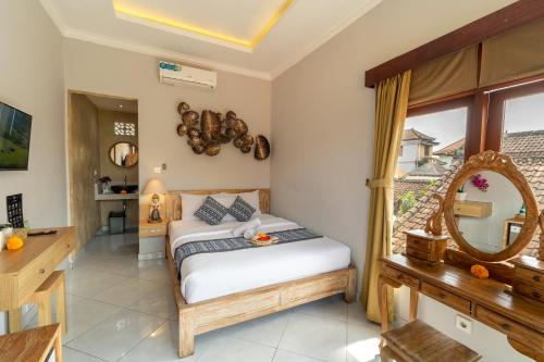 a bedroom with a bed and a mirror at Ubud Heritage Stay by Dhananjaya Hospitality in Ubud