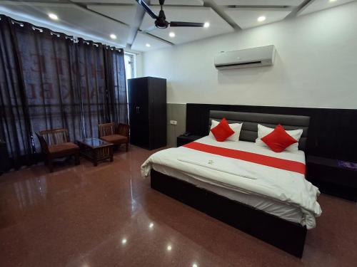 a bedroom with a large bed with red pillows at Hotel Park Blu in Pānīpat