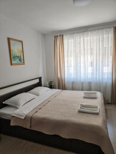a bedroom with a large bed with two towels on it at Apartman Matej in Gospić