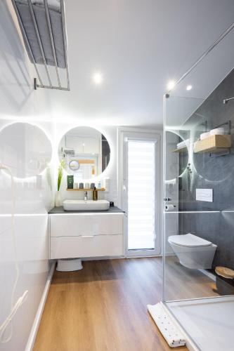 a white bathroom with a sink and a toilet at Chalet Stuhleckblick Ferienhaus mit Sauna, Panorama und Terrasse in Spital am Semmering