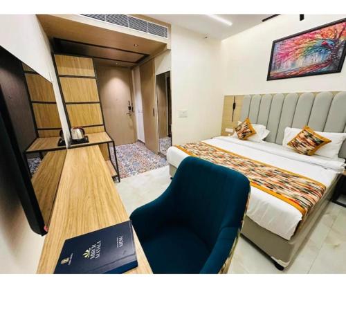 a hotel room with a bed and a blue chair at Evara Exotica in Darbhanga