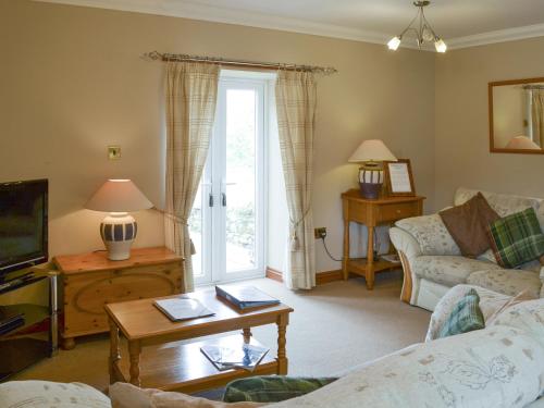 a living room with a couch and a tv at Waren View in Warenford