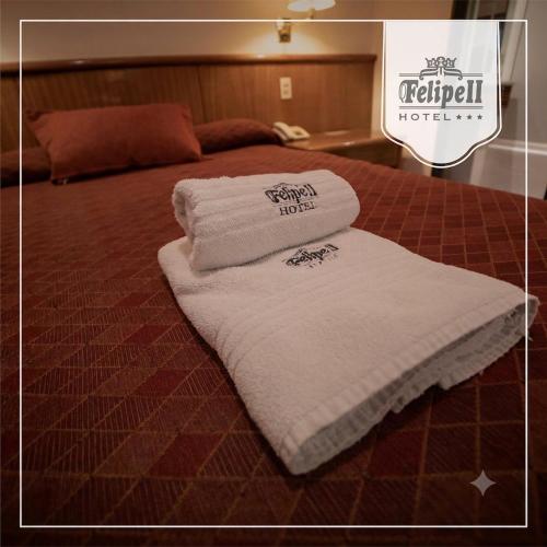 Ein Stapel Handtücher lag auf einem Bett. in der Unterkunft Hotel Felipe II in Cordoba