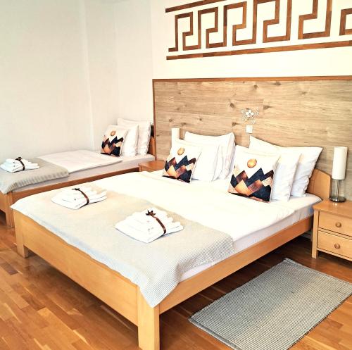 two twin beds in a room with wooden floors at Plitvice Lower Lakes Rooms in Plitvica Selo