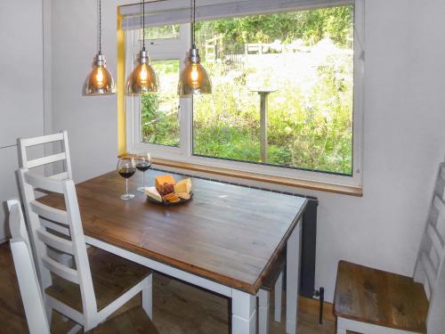 a dining room table and chair with a window at Briardene Cottage in Whitestone