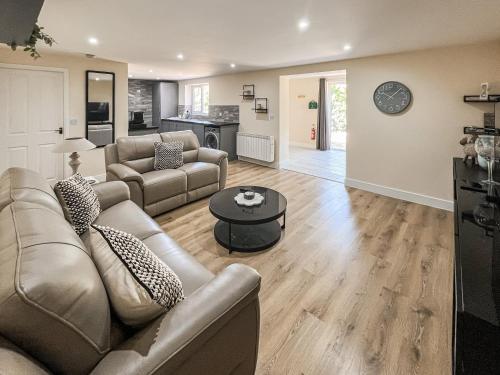 a living room with a couch and a table at Jubilee Farm Cottage in Washingborough