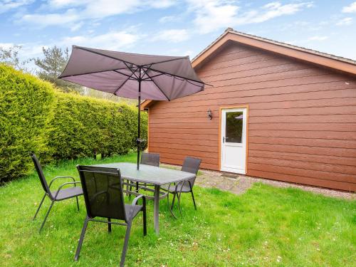 a table and chairs with an umbrella in a yard at Swallow - Uk41035 in Marston