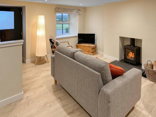 a living room with a couch and a fireplace at Wagglehead Cottage in Aboyne