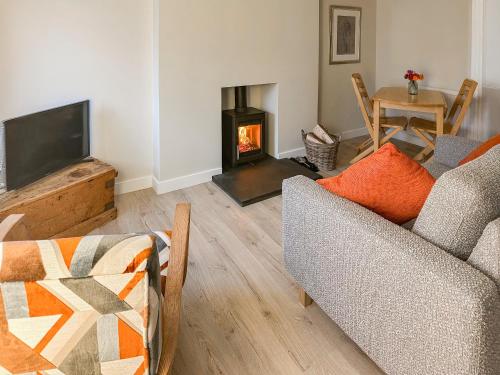 a living room with a couch and a fireplace at Wagglehead Cottage in Aboyne