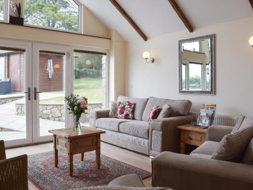 a living room with a couch and a table at Brynymor Cottage in Llangennith