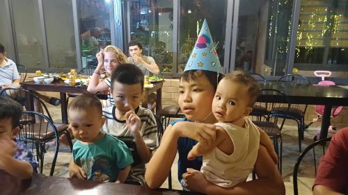 a group of children sitting at a table wearing a birthday hat at Tình's Homestay in Ninh Binh