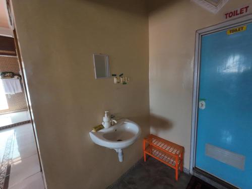 a bathroom with a white sink in a room at Fathin Hotel Bawean Syariah in Sangkapura