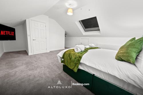 a bedroom with a bed and a tv on the wall at AltoHaus Luxury 4BR House By AltoLuxo Short Lets & Serviced Accommodation With Parking in Bristol