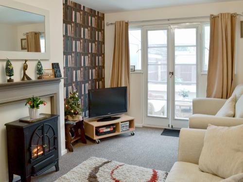 a living room with a fireplace and a television at Oak Lodge in Longham