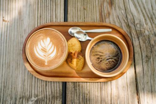 ein Holztablett mit einer Tasse Kaffee und Brot in der Unterkunft Kazerne Hotel - Member of Design Hotels in Eindhoven