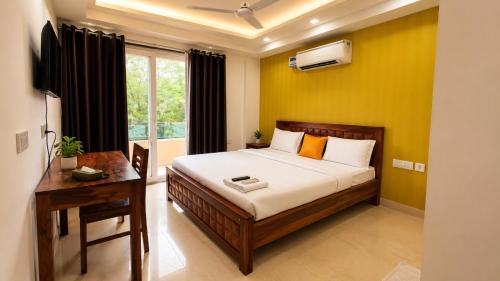 a bedroom with a bed and a desk and a window at Lime Tree Hotel Golf Course Extension Nearby Grand Hyatt Gurgaon in Gurgaon