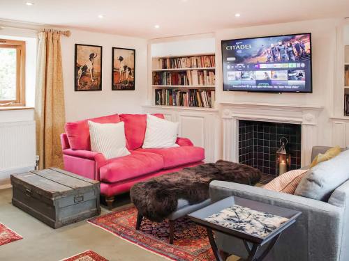 a living room with a red couch and a fireplace at The Granary - Uk52147 in Brundall