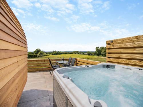 a hot tub on a patio with a table and chairs at Rabbits Rest - Uk46128 in Nesscliffe