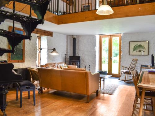 a living room with a couch and a fireplace at Swallows Barn in Liskeard