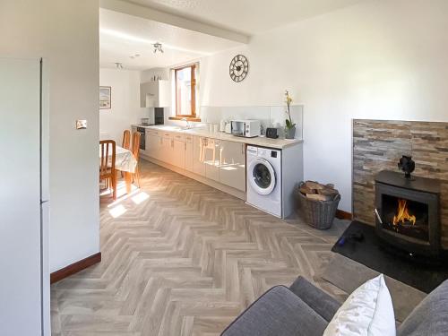 a living room with a fireplace and a stove at Maple Cottage in Inverallochy