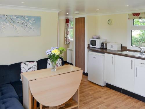 a kitchen with a couch and a table with flowers on it at White Moth - Uk12697 in Stalham