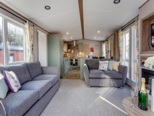 a living room with two couches and a kitchen at The Pines in Aviemore