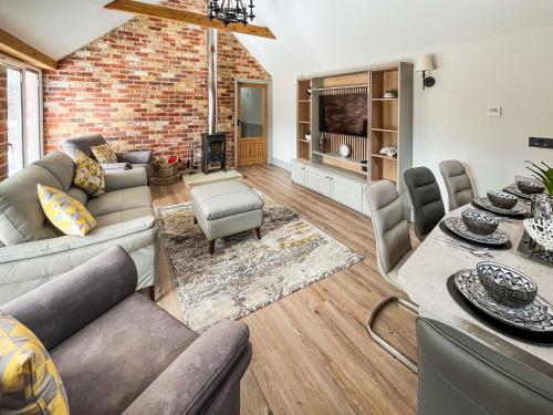 a living room with a couch and a table at Rose Blossom Cottage in Benniworth