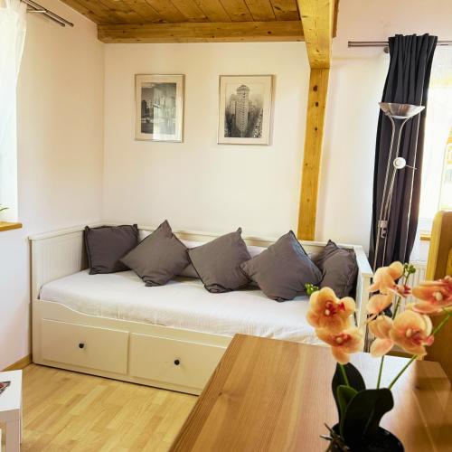 a room with a white couch with pillows at FeWo Mangfall in Bruckmühl
