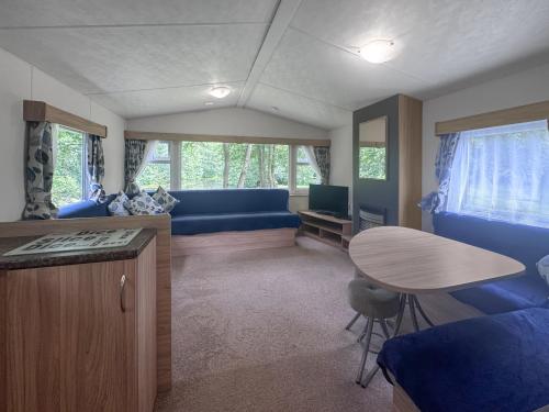 a living room with a blue couch and a table at Mallard - Uk52121 in Hevingham