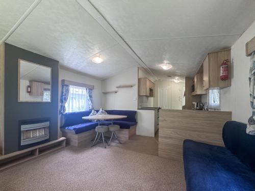 a living room with a table and a kitchen at Mallard - Uk52121 in Hevingham