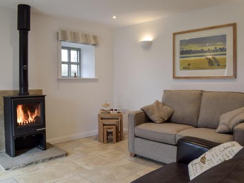 a living room with a couch and a fireplace at Five Barred Gate Barn in Inglewhite