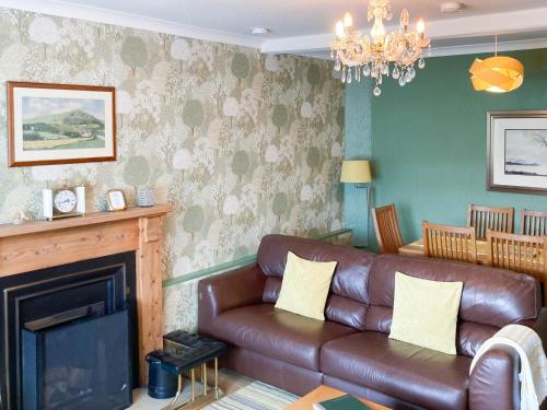 a living room with a couch and a fireplace at Balnowlart Lodge in Ballantrae