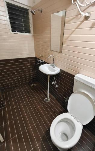 a bathroom with a toilet and a sink at Aura Vista in Bhopal