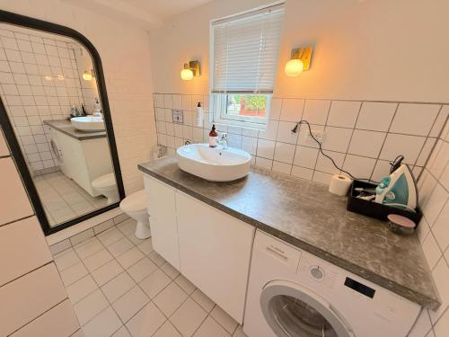 a bathroom with a sink and a washing machine at Studio Next to CPH Airport with Outdoor Space in Copenhagen