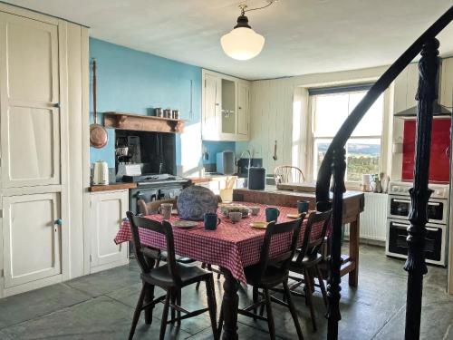 a kitchen with a table with a red tablecloth on it at Downhouse in Delabole