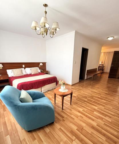 a bedroom with a bed and a blue couch at Hostal Del Sol Spa in Termas de Río Hondo