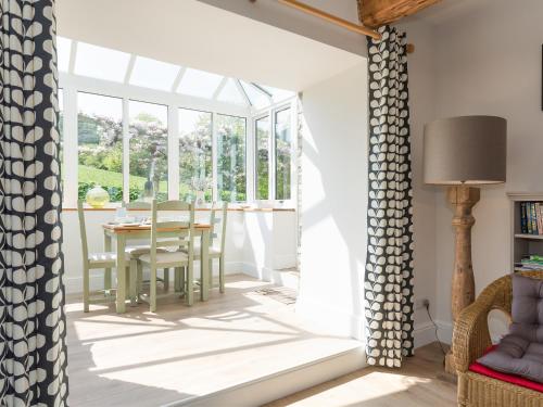 a conservatory with a table and chairs and a window at The Barn - Uk2475 in West Witton