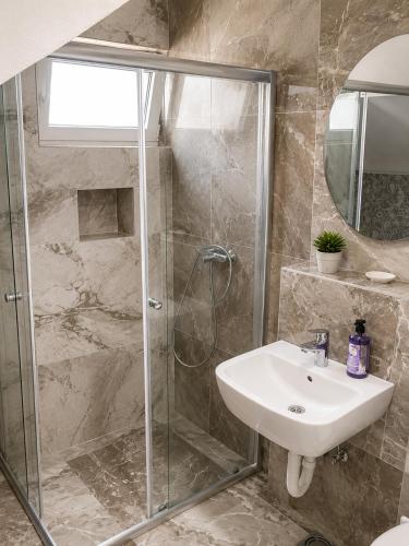 a bathroom with a shower and a sink at Two Palms Apartment in Sutomore