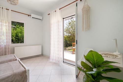 a white room with a sliding glass door and a plant at A casa d'Irene in Amalias
