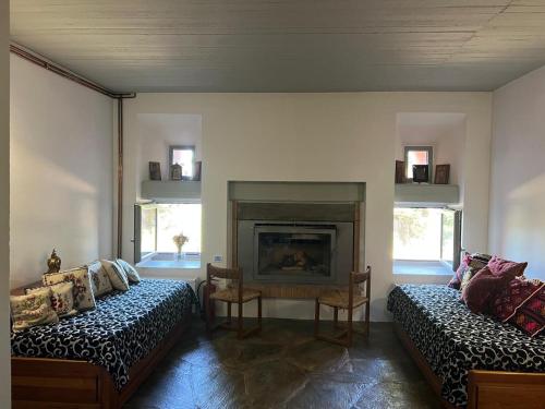 a living room with two beds and a fireplace at Seta Forest House in Séta