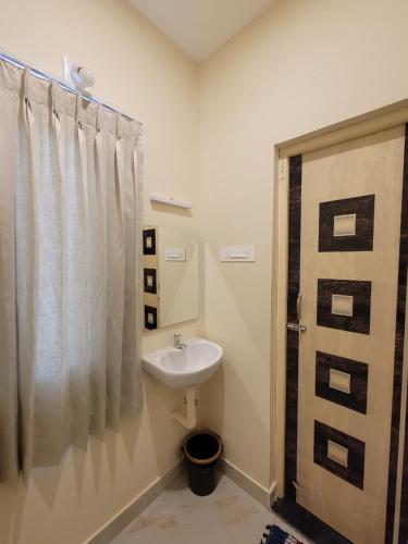 a bathroom with a sink and a shower curtain at Sri Balakrishna Residency in Thiruchendur